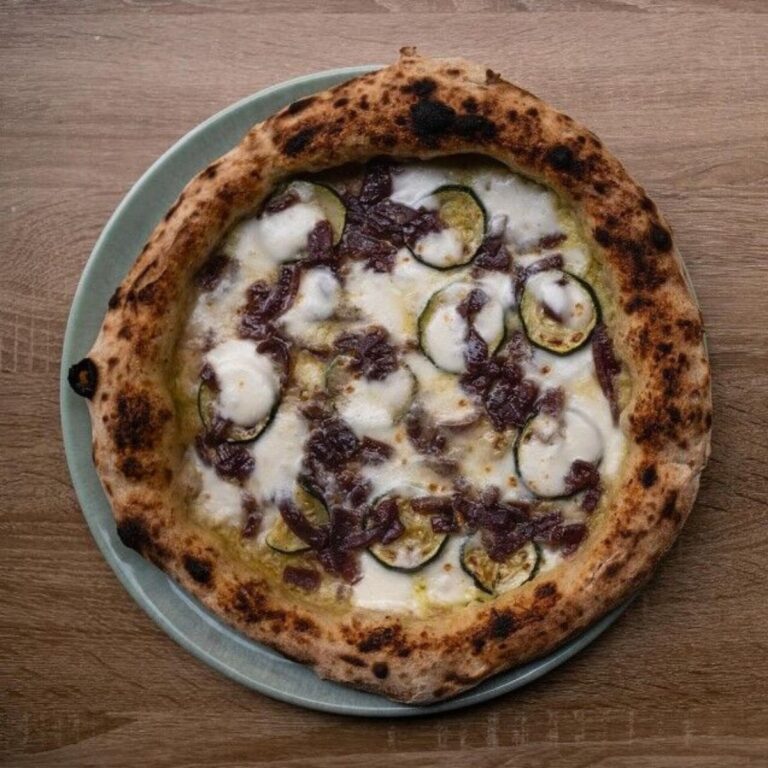 Pizza contemporanea dal cornicione pronunciato farcita con zucchine e cipolla caramellata.